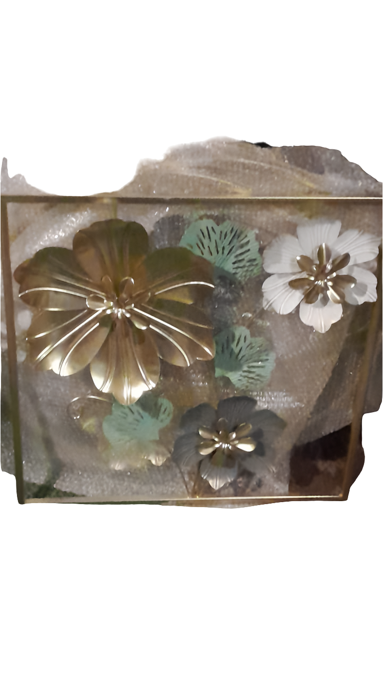 A square metal wall art piece featuring three-dimensional metal flowers and leaves in a gold frame